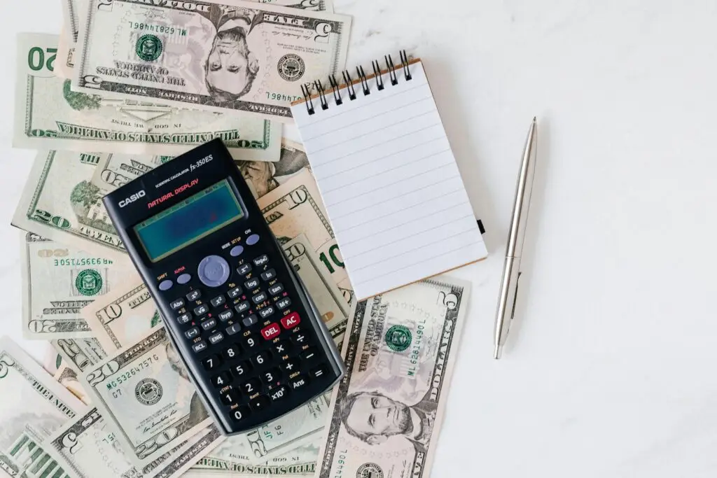 pexels-photo-4386373-4386373 Flat lay of US dollar bills with calculator and notebook for budgeting.